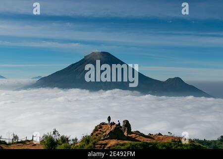 Vue sur les montagnes de Sindoro avec une mer de ​​clouds dans le centre de Java, Indonésie du haut tôt le matin Banque D'Images