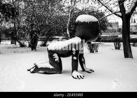 PRAGUE, RÉPUBLIQUE TCHÈQUE - 14 JANVIER 2021 : bébés - des sculptures en bronze sont installées sur l'île de Kampa à Prague, République tchèque. Artiste: David Cerny. Sculptures couvertes de neige en hiver. Image en noir et blanc. Banque D'Images