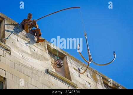 Sculpture en fer d'oeuvre d'un homme pêchant avec un crochet très grand au quartier général de Steampunk, Oamaru, Nouvelle-Zélande. Banque D'Images