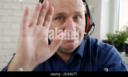 Homme travaillant à la maison et parlant dans un appel vidéo en utilisant la webcam d'ordinateur portable et les casques, social distancer dans Covid-19 pandémie, travail à distance de la maison Banque D'Images