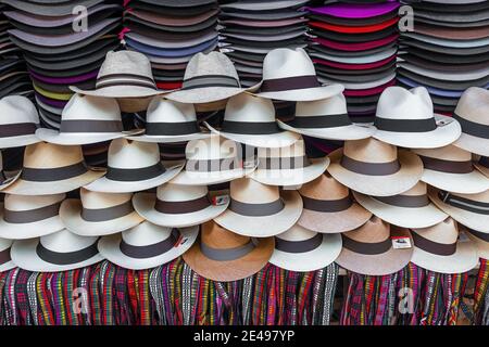 Stand avec des chapeaux Panama et des bracelets colorés à vendre sur le marché de l'art et de l'artisanat Otavalo, Equateur. Banque D'Images