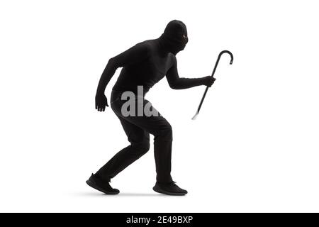 Plein plan d'un cambrioleur dans des vêtements noirs avec une balaclava et un crowbar marchant lentement isolés sur blanc arrière-plan Banque D'Images