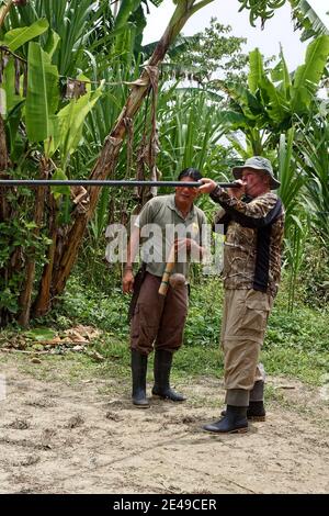 Homme utilisant un fusil de soufflage; vêtements de camouflage; enseignement de guide masculin autochtone; compétence, arme, Amérique du Sud, forêt tropicale amazonienne, Equateur, MR Banque D'Images