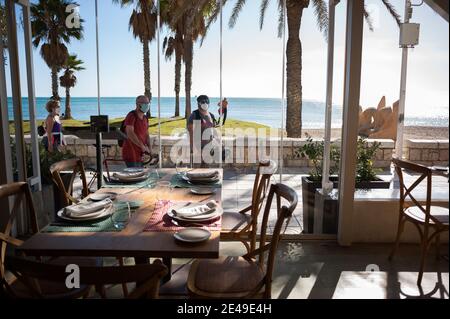 Malaga, Espagne. 22 janvier 2021. Les personnes portant des masques de protection contre la propagation du covid-19 regardant un restaurant vide à la plage de la Malagueta dans un contexte de pandémie de coronavirus.la région d'Andausia souffre d'une augmentation quotidienne incontrôlée des cas de coronavirus, malgré les restrictions sévères imposées dans la vie quotidienne. Au cours des dernières semaines, l'Andalousie a signalé des milliers d'infections chaque jour dans la région tandis que la pression hospitalière continue d'augmenter. Crédit : SOPA Images Limited/Alamy Live News Banque D'Images