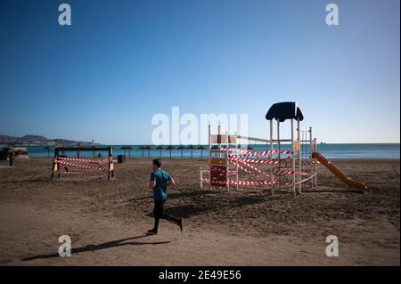 Malaga, Espagne. 22 janvier 2021. Un homme qui fait du jogging autour d'un parc fermé à la plage de la Malagueta, dans le cadre d'une pandémie de coronavirus.la région d'Andausia souffre d'une augmentation quotidienne incontrôlée des cas de coronavirus, malgré des restrictions sévères imposées dans la vie quotidienne. Au cours des dernières semaines, l'Andalousie a signalé des milliers d'infections chaque jour dans la région tandis que la pression hospitalière continue d'augmenter. Crédit : SOPA Images Limited/Alamy Live News Banque D'Images