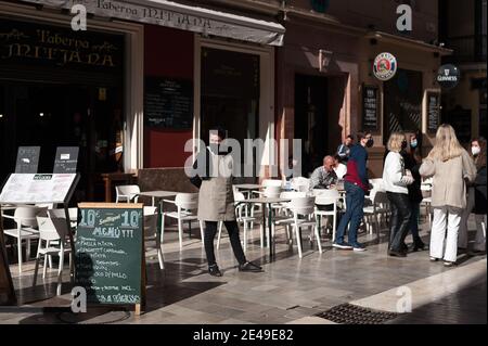 Malaga, Espagne. 22 janvier 2021. Un employé a été vu attendre des clients à l'extérieur du bar Mitjana, dans la rue Caldereria, au milieu d'une pandémie de coronavirus.la région d'Andausia souffre d'une augmentation quotidienne incontrôlée des cas de coronavirus, en dépit des restrictions strictes imposées dans la vie quotidienne. Au cours des dernières semaines, l'Andalousie a signalé des milliers d'infections chaque jour dans la région tandis que la pression hospitalière continue d'augmenter. Crédit : SOPA Images Limited/Alamy Live News Banque D'Images