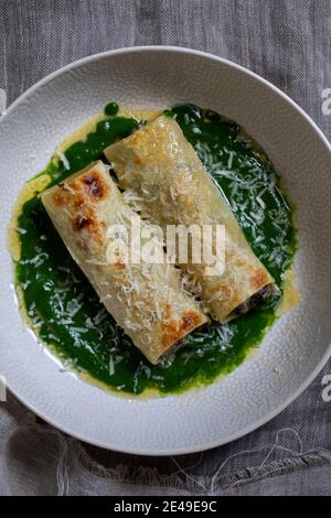 Cannelloni aux champignons, épinards et ricotta chesse dans une sauce aux épinards Banque D'Images