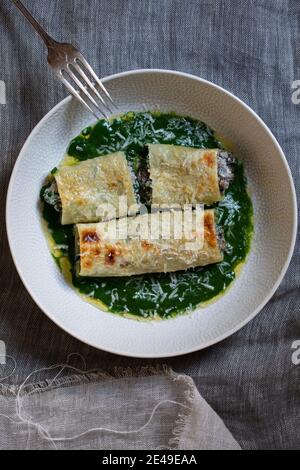 Cannelloni aux champignons, épinards et ricotta chesse dans une sauce aux épinards Banque D'Images