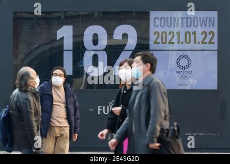 Tokyo, Japon. 22 janvier 2021. Des piétons portant des masques de visage marchent devant un écran affichant un compte à rebours pour les Jeux Olympiques de Tokyo 2020 à Tokyo. Le président du Comité olympique japonais (JOC), Yasuhiro Yamashita, a rejeté vendredi les rapports des médias selon lesquels le gouvernement japonais a conclu en privé que les Jeux olympiques de Tokyo devront être annulés cette année en raison de la pandémie du coronavirus. Credit: Rodrigo Reyes Marin/ZUMA Wire/Alay Live News Banque D'Images