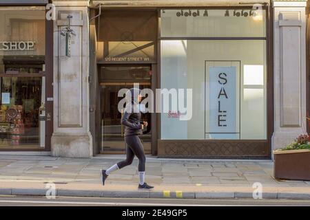 Londres, Royaume-Uni. 22 janvier 2021. Une femme qui fait du jogging le long de Regent Street pendant le confinement de Covid-19. Crédit : SOPA Images Limited/Alamy Live News Banque D'Images