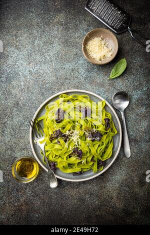 Pâtes Tagliatelle vertes au chou-fleur pourpre sur fond bleu, vue du dessus Banque D'Images