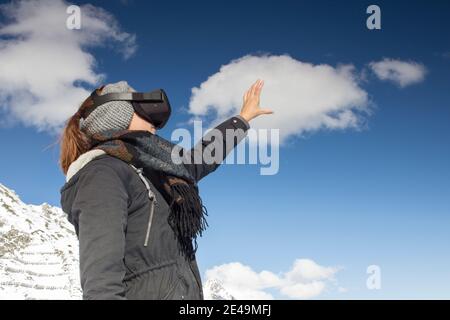 Personne mit Virtual-Reality-Brille vor Bergkulisse Banque D'Images