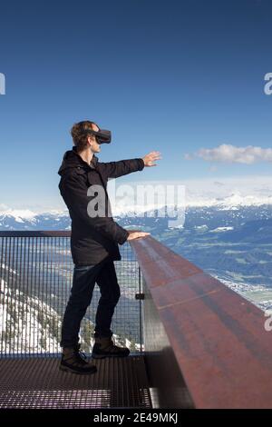 Personne mit Virtual-Reality-Brille vor Bergkulisse Banque D'Images