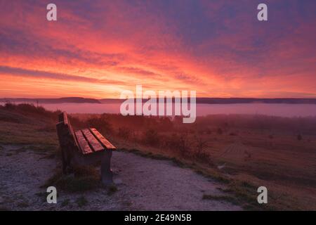 Des altocumulus rouges lumineux se trouvent au lever du soleil sur un banc de Napoleonstein avec la vallée de la Saale inondée de brouillard en arrière-plan, Jena, Thuringe, Allemagne Banque D'Images