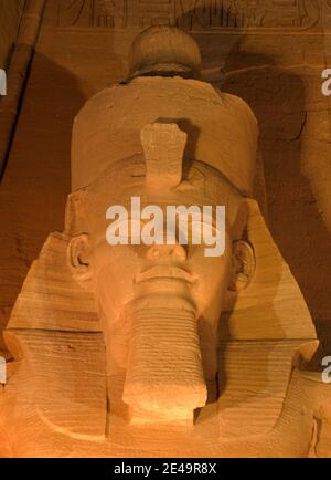 Afrique du Nord Égypte Abu Simbel temple de Ramsès II gros plan de la statue de tête sculptée dans la pierre la nuit illuminée - son et lumière spectacle Banque D'Images