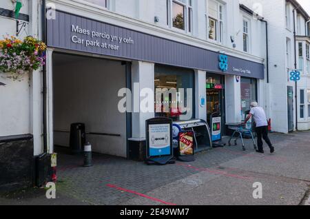 Bala; Royaume-Uni: 20 septembre 2020: Un client pousse un chariot à l'entrée du supermarché Coop sur High Street. La signalétique donne aux clients Banque D'Images