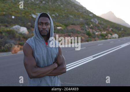 Portrait de l'homme afro-américain en bonne forme dans les vêtements de sport debout une route côtière Banque D'Images