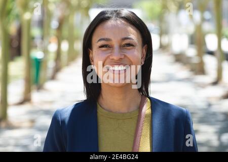 Portrait d'une femme afro-américaine souriant dans la rue. Mode de vie vivant pendant la pandémie du coronavirus Covid 19. Banque D'Images