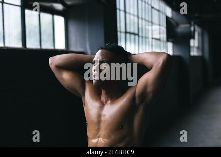 Homme afro-américain debout et en flexion ses muscles en vide bâtiment urbain Banque D'Images