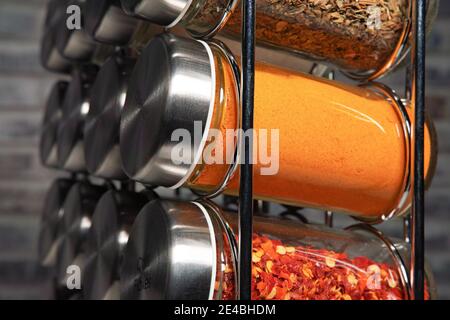 Un porte-épices en métal avec de nombreuses bouteilles de verre remplies de différentes épices, prise studio Banque D'Images