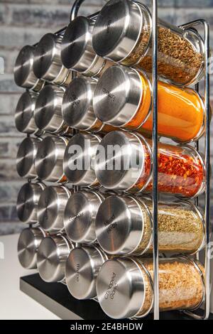 Un porte-épices en métal avec de nombreuses bouteilles de verre remplies de différentes épices, prise studio Banque D'Images
