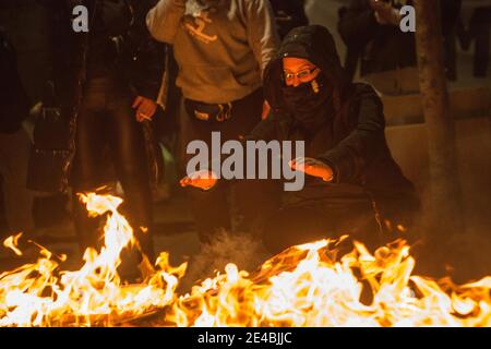 Barcelone, Catalogne, Espagne. 22 janvier 2021. Protesster est vu se réchauffer dans le feu de joie.l'Union de logement du quartier de Raval de Barcelone a appelé une manifestation pour exiger de la ville des solutions pour un bâtiment qui est sans aucune installation et une alternative de logement pour tous les résidents dans le quartier qui souffrent de l'énergie et de l'eau coupes. Credit: Thiago Prudencio/DAX/ZUMA Wire/Alay Live News Banque D'Images