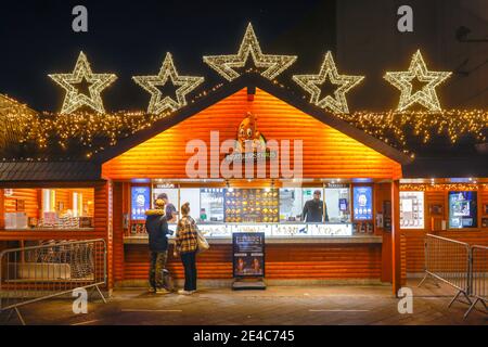 Bochum, région de la Ruhr, Rhénanie-du-Nord-Westphalie, Allemagne - Bratwursthaus, le snack-bar le plus populaire de Bochum au Triangle des Bermudes dans le centre-ville de Bochum en temps de crise de la corona pendant la deuxième partie du confinement, passe-près avec des masques protecteurs sur la Kortumstrasse décorée de Noël, la principale rue commerçante de la zone piétonne. Banque D'Images