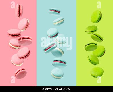 Des macarons colorés levèrent sur fond rose, bleu et vert Banque D'Images