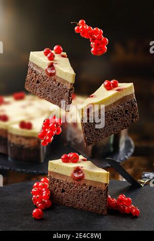 Concept de confiserie avec des gâteaux volants avec cassis rouge, mouss au chocolat et crème au fromage sur le dessus. Dessert sain frais et cuit à la levité. Banque D'Images