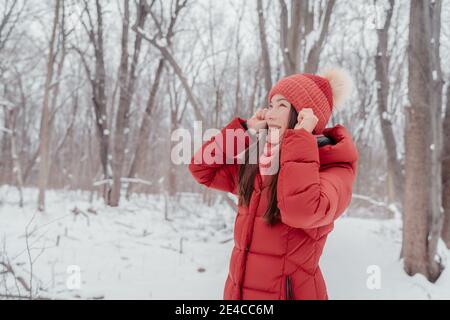 Hiver bonne femme asiatique à la recherche de s'amuser dans le parc naturel extérieur. Beauté sèche soins de la peau concept de visage, comment protéger du froid Banque D'Images