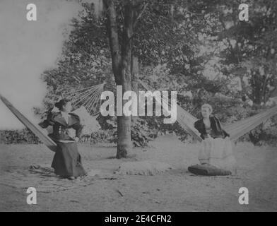 Archive américaine portrait monochrome de deux femmes assises dans des hamacs de jardin face à l'autre. Prise à la fin du XIXe siècle à Port Byron, NY, États-Unis Banque D'Images