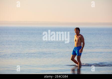 Homme en forme à cinquante plus tôt le matin dans la mer. Randonnée dans la mer Baltique sur la plage de Scharbeutz Banque D'Images