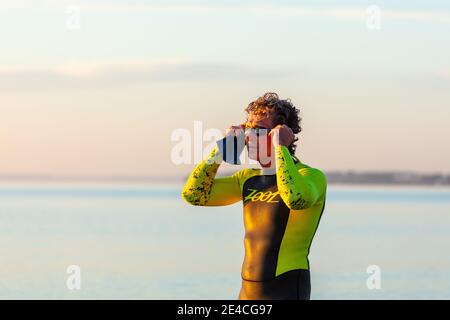 Homme 50 plus FIT, avec une combinaison dans la mer. Préparation à l'entraînement à la natation en mer Baltique. Banque D'Images