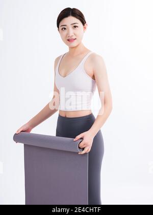 Tapis de yoga pour les jeunes femmes souriant en regardant le objectif Banque D'Images