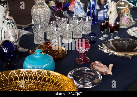 Coupes en cristal, verres, assiettes, porcelaine, poterie et autres objets exposés sur un marché aux puces Banque D'Images