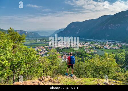 Montan, province de Bolzano, Tyrol du Sud, Italie. Un randonneur sur l'ascension de la colline de Castelfeder, où l'on rencontre des traces de préhistoire et de la haute colonie médiévale. Dans la vallée, le village d'Auer Banque D'Images