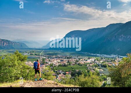 Montan, province de Bolzano, Tyrol du Sud, Italie. Un randonneur sur l'ascension de la colline de Castelfeder, où l'on rencontre des traces de préhistoire et de la haute colonie médiévale. Dans la vallée, le village d'Auer Banque D'Images