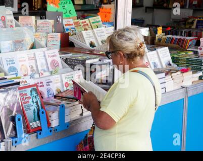 Coruna-Espagne. Femme lisant un livre dans un stand d'une foire de livres anciens le 19 août 2019 Banque D'Images