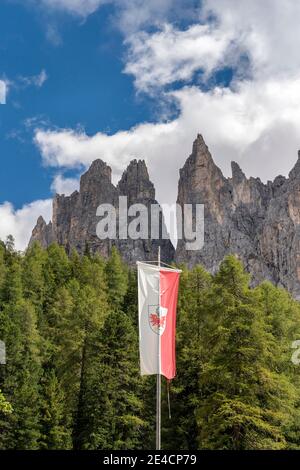 Tiers, Tierser Tal, province de Bolzano, Dolomites, Tyrol du Sud, Italie. Le drapeau du Tyrol du Sud devant les Tours Vajolet Banque D'Images