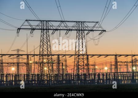 Lever du soleil, pylônes à courant lourd, pylônes électriques, lignes électriques, sous-station Wolmirstedt, Saxe-Anhalt, Allemagne Banque D'Images