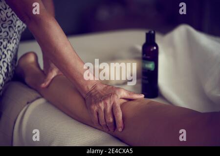 Gros plan des mains d'une masseuse professionnelle sur le dos d'une femme recevant un massage corporel intégral. Banque D'Images