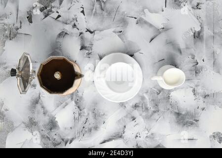 Vue de dessus de la machine à café geyzsr, tasse et pot avec lait sur fond abctract Banque D'Images