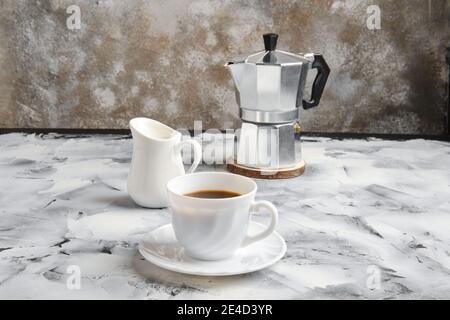 Cafetière geyser, tasse et pot avec lait sur fond abctract Banque D'Images