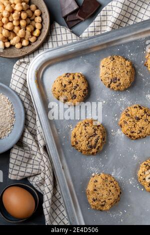 Composition verticale d'une plaque de cuisson avec des pois chiches fraîchement cuits biscuits et chocolat noir Banque D'Images