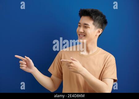 homme asiatique avec deux doigts de côté Banque D'Images