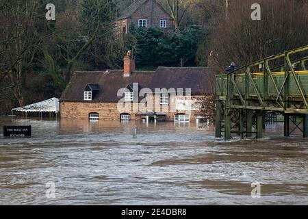 Shropshire, Royaume-Uni. 23 janvier 2021. Les niveaux de la rivière Severn dans le Shropshire ont continué d'augmenter durant la nuit, causant des inondations graves dans certaines régions. Le village de Jackfield, situé sur le site du patrimoine mondial de la gorge d'Ironbridge, a été particulièrement touché, avec des maisons et des entreprises très inondées. Les niveaux sont très proches des inondations records de février 2020. Un homme s'arrête pour prendre une photo de l'auberge de bateau inondée depuis la passerelle. Crédit : Rob carter/Alay Live News Banque D'Images