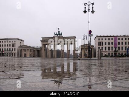 Berlin, Allemagne. 23 janvier 2021. La porte de Brandebourg se reflète dans les eaux de pluie de Pariser Platz. Credit: Paul Zinken/dpa/Alay Live News Banque D'Images