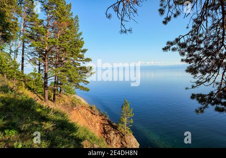 Vue sur le lac Baikal depuis la rive boisée. Au loin, les montagnes Hamar-Daban sont en arrière-plan. Région d'Irkoutsk Banque D'Images