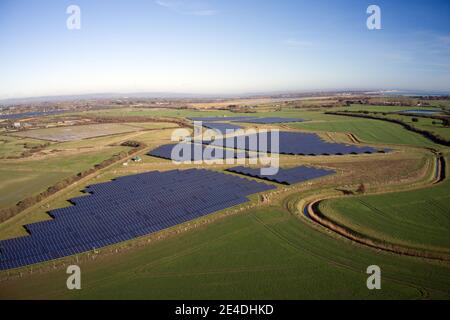 Vue aérienne d'une grande ferme de panneaux solaires dans la belle campagne du sud de l'Angleterre. Banque D'Images