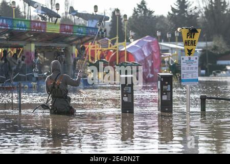 Stourport-on-Severn, Worcestershire, Royaume-Uni. 23 janvier 2021. Un pêcheur à la ligne profite aujourd'hui d'un parc automobile inondé à Stourport-on-Severn, dans le Worcestershire, alors que la rivière Severn éclate ses berges. Le niveau de la rivière est toujours en hausse et devrait atteindre son sommet plus tard aujourd'hui. Crédit : Peter Lophan/Alay Live News Banque D'Images